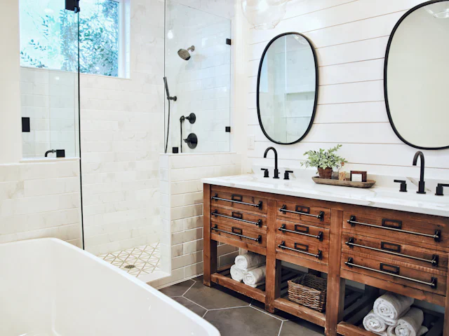 Bathroom with a reclaimed-wood double vanity, shiplap wall, black fixtures, oval mirrors and a tiled walk-in shower